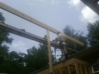 Carpenter setting a ridge beam over a new addition frame — Ice Dam Removal by Roofing Brothers in Hackensack