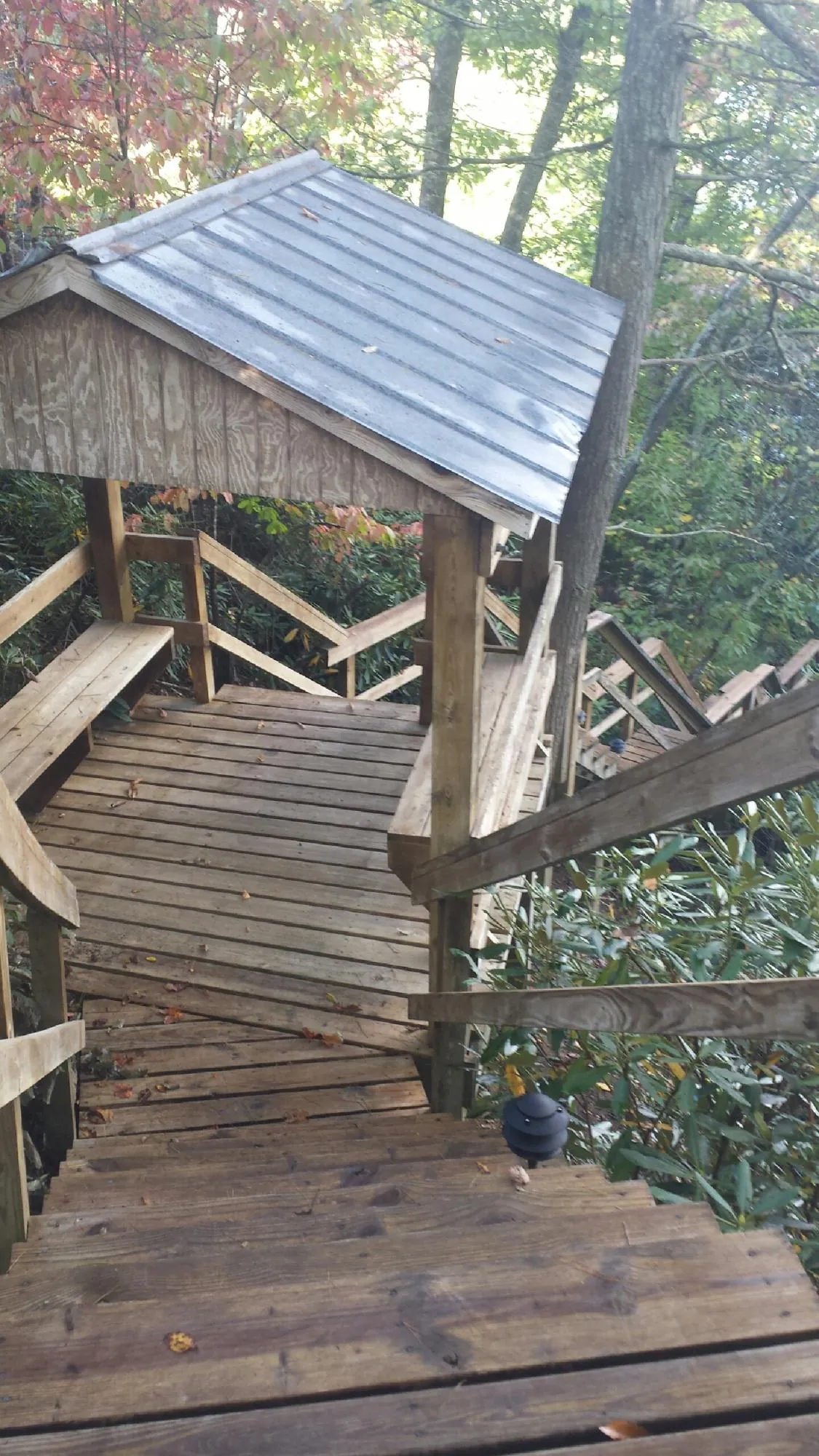 Metal roofed shelter over wooden steps on a wooded walkway — Skylight Repair & Installation work by our crew in Hackensack